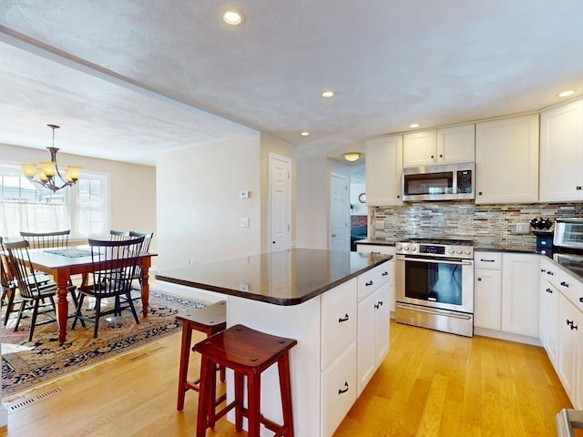 kitchen featuring dark countertops, light wood-type flooring, and stainless steel appliances