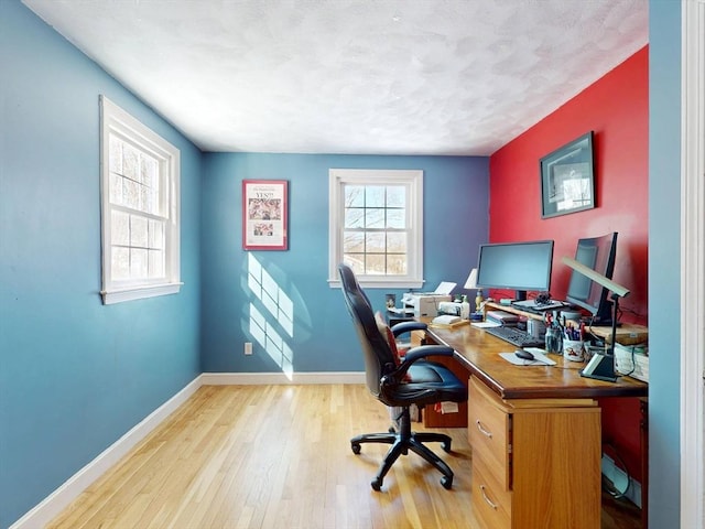 home office featuring a healthy amount of sunlight, baseboards, and wood finished floors