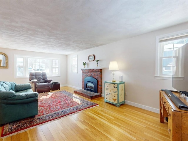 living room featuring baseboards, a fireplace, and hardwood / wood-style floors