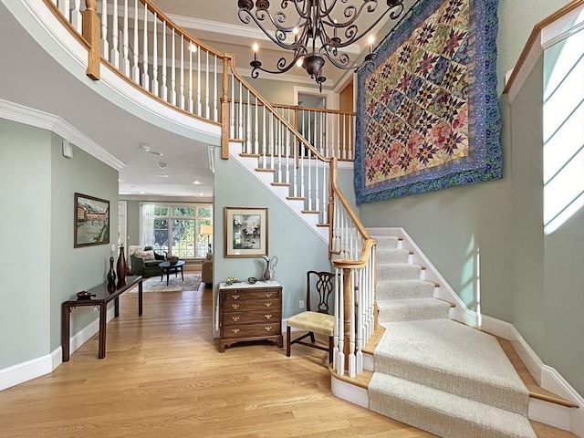 32 Twitchell St, Wellesley, MA 02482 - stairs with ornamental molding, wood finished floors, a high ceiling, baseboards, and a chandelier
