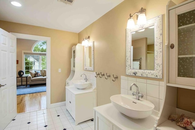 32 Twitchell St, Wellesley, MA 02482 - ensuite bathroom featuring a sink, tile patterned flooring, a stall shower, and decorative backsplash