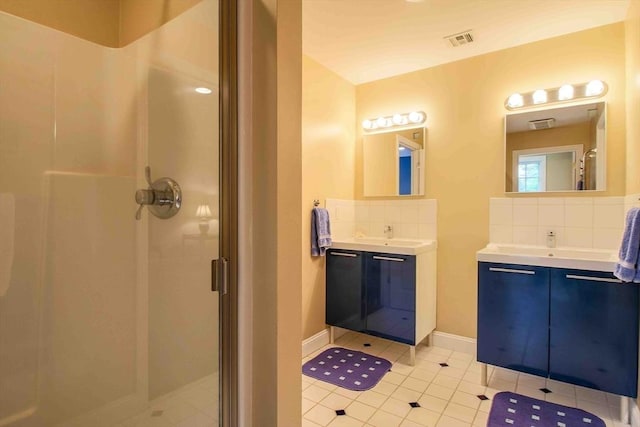 32 Twitchell St, Wellesley, MA 02482 - bathroom featuring backsplash, a shower stall, tile patterned floors, and two vanities