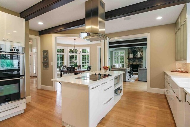 32 Twitchell St, Wellesley, MA 02482 - kitchen featuring black electric stovetop, island range hood, double oven, beam ceiling, and baseboards