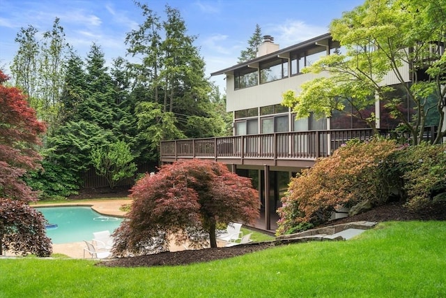 12 Laurus Ln, Newton, MA 02459 - back of property featuring an outdoor pool, a chimney, and a lawn