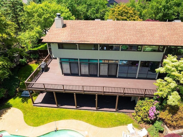 12 Laurus Ln, Newton, MA 02459 - rear view of house featuring a shingled roof, a deck, a chimney, and a yard