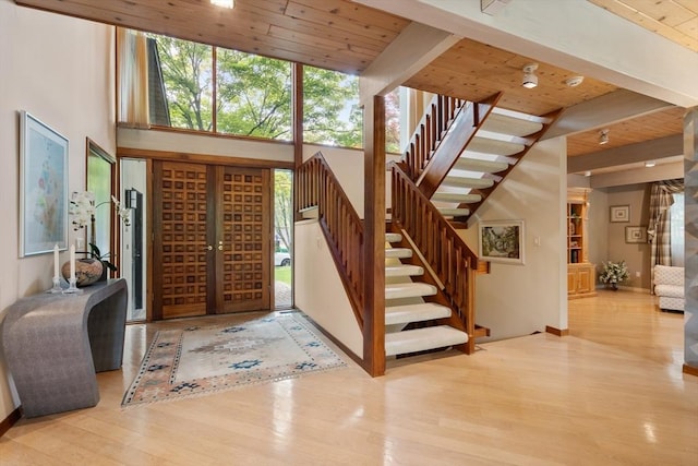 12 Laurus Ln, Newton, MA 02459 - foyer featuring a wooden ceiling with exposed beams, stairs, healthy amount of natural light, wood finished floors, and a high ceiling