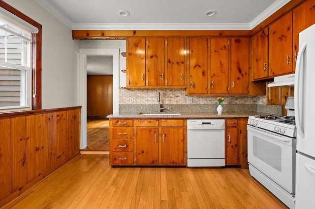 kitchen featuring white appliances, crown molding, tasteful backsplash, sink, and light wood-type flooring