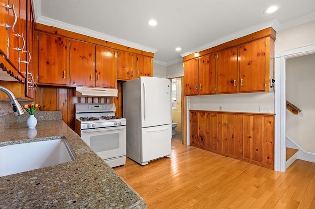 kitchen with white appliances, crown molding, sink, light hardwood / wood-style flooring, and stone counters