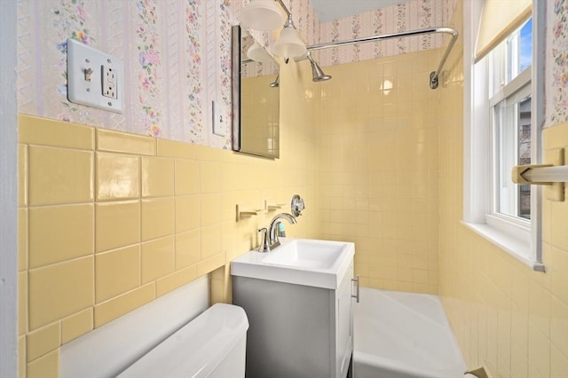 full bathroom with vanity, toilet, tiled shower / bath, and backsplash