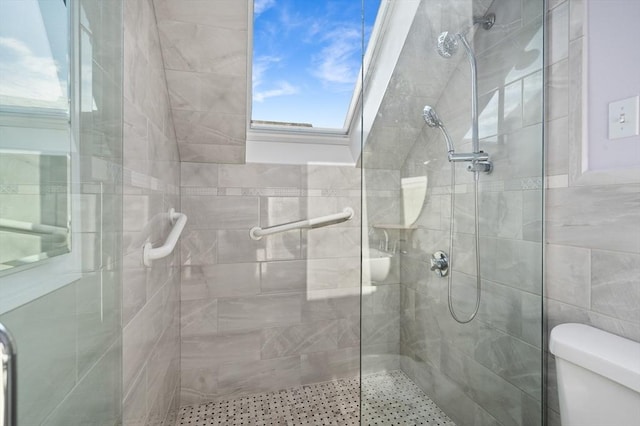 bathroom with toilet and a shower with door