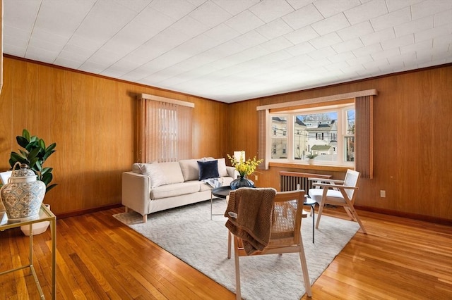 living room featuring wood-type flooring and ornamental molding