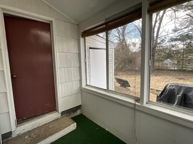 unfurnished sunroom featuring vaulted ceiling