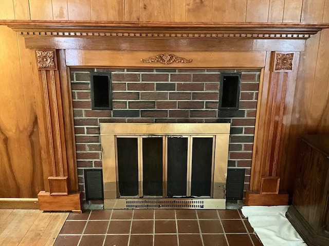 details with a brick fireplace and wood walls