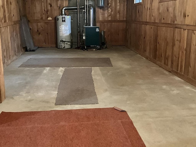 basement featuring gas water heater and wooden walls