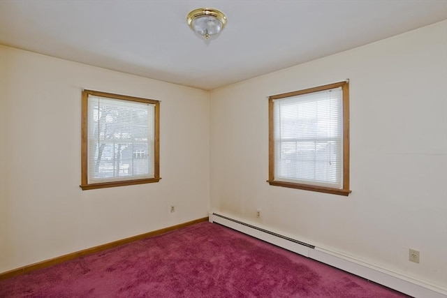 carpeted spare room with a baseboard heating unit