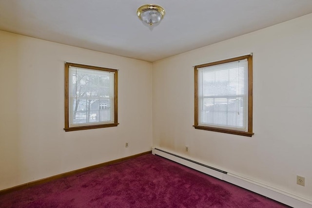 spare room featuring carpet floors and a baseboard heating unit