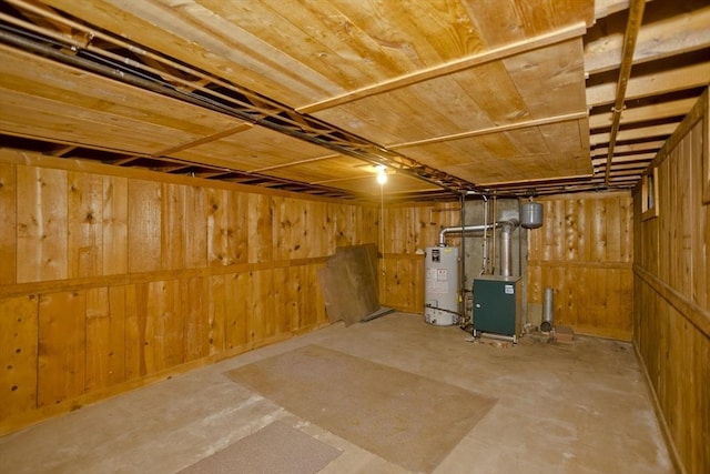 basement featuring wooden ceiling, water heater, and wood walls