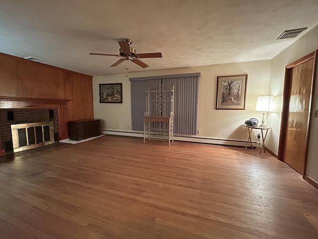 unfurnished living room featuring hardwood / wood-style flooring, a fireplace, and ceiling fan