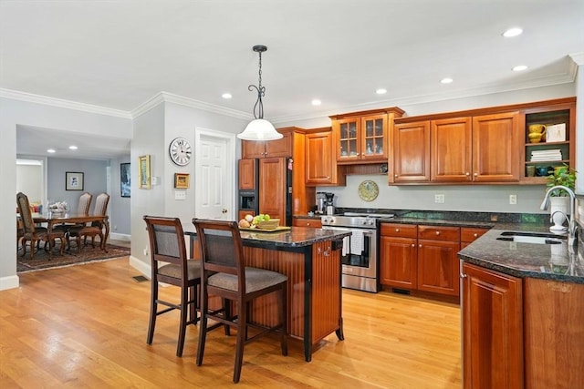 149 Acorn St, Marshfield, MA 02050 - kitchen featuring gas range, paneled fridge, a sink, brown cabinetry, and a breakfast bar area