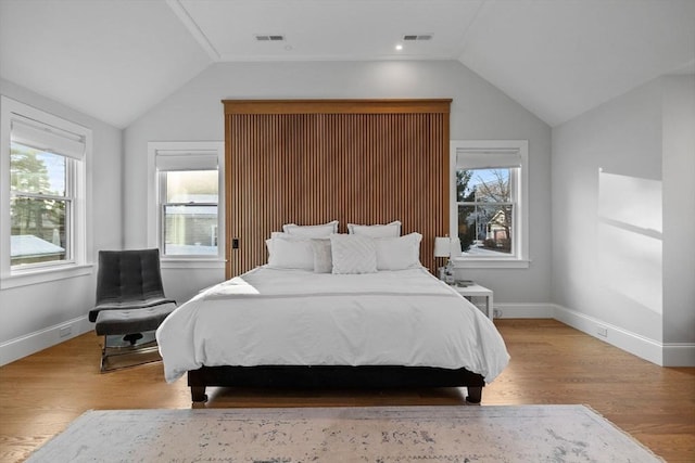 bedroom with lofted ceiling and light wood-type flooring