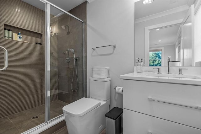 bathroom with vanity, crown molding, a shower with door, and toilet