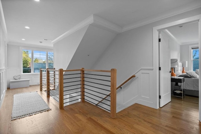 stairway with crown molding and hardwood / wood-style floors