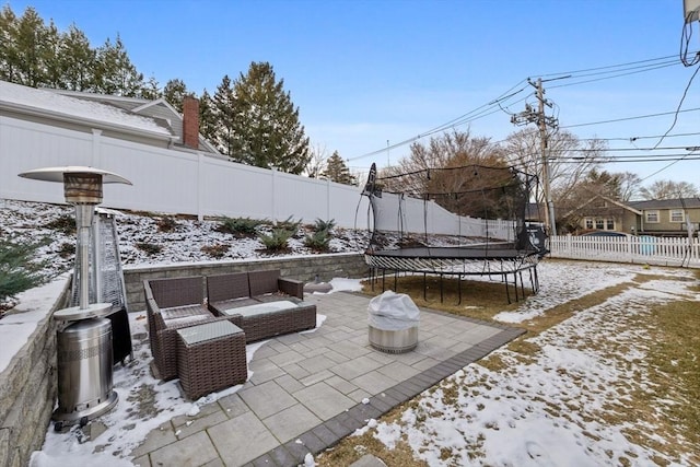 snow covered patio featuring a trampoline and outdoor lounge area