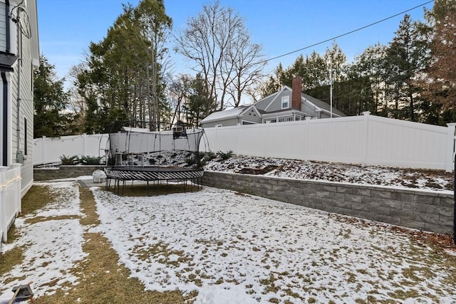 yard covered in snow with a trampoline