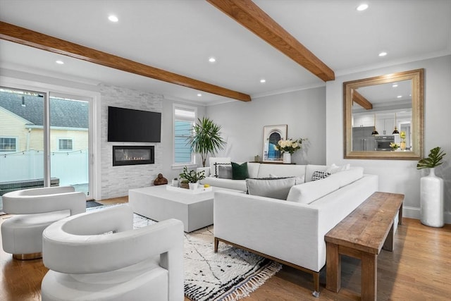 living room with beam ceiling, light hardwood / wood-style flooring, and a large fireplace