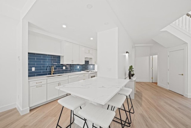 44 Ober Rd Unit 44, Newton, MA 02459 - kitchen featuring a sink, white appliances, light wood-style floors, a kitchen breakfast bar, and recessed lighting