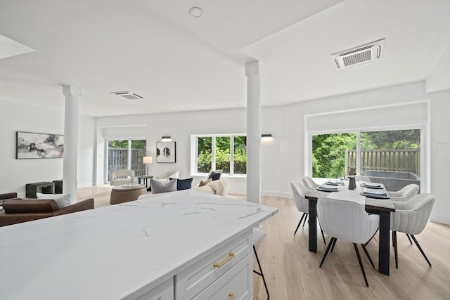 44 Ober Rd Unit 44, Newton, MA 02459 - kitchen featuring ornate columns, open floor plan, light stone counters, and light wood-style flooring