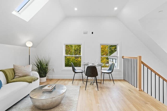 interior space featuring vaulted ceiling with skylight and light wood-type flooring