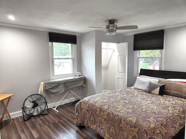 bedroom featuring multiple windows, wood finished floors, baseboards, and ornamental molding