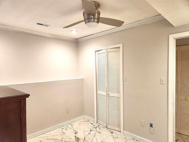 unfurnished bedroom with marble finish floor, a textured ceiling, visible vents, ceiling fan, and baseboards