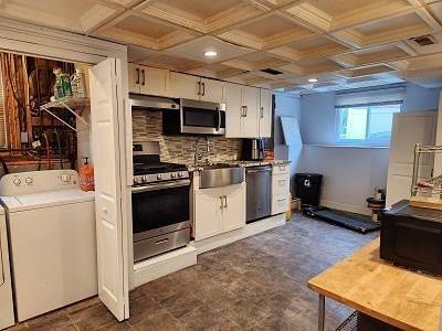22 Osceola Ln, Billerica, MA 01821 - kitchen with washer / dryer, stainless steel appliances, a sink, white cabinetry, and tasteful backsplash