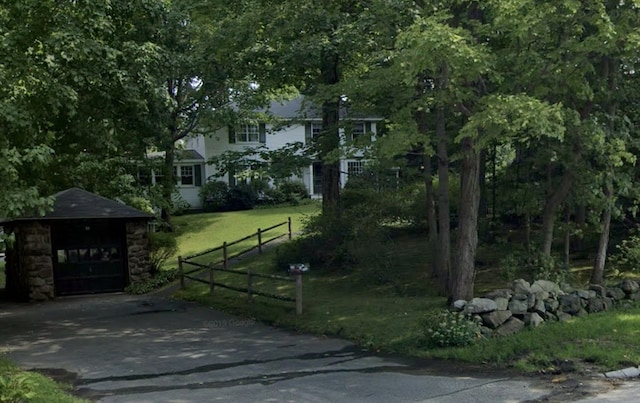 view of gate featuring an outdoor structure and a yard