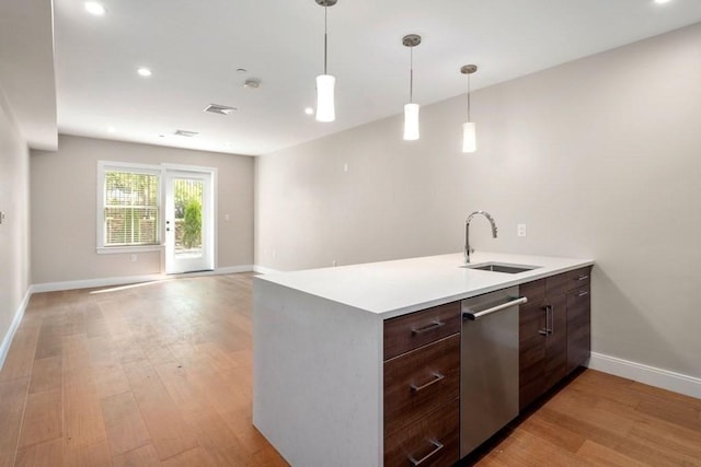 425 Lagrange St Unit 107, Boston, MA 02132 - kitchen featuring a sink, stainless steel dishwasher, baseboards, light wood finished floors, and light countertops