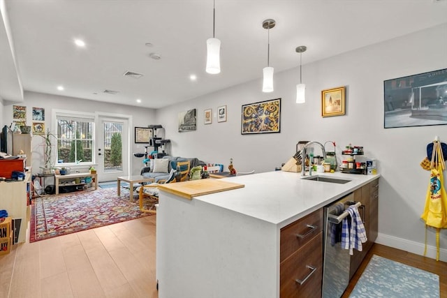 425 Lagrange St Unit 107, Boston, MA 02132 - kitchen featuring a sink, dishwasher, light wood-style flooring, decorative light fixtures, and recessed lighting