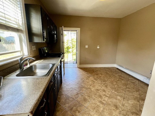 kitchen with dark brown cabinetry, baseboard heating, sink, black gas stove, and light tile patterned flooring