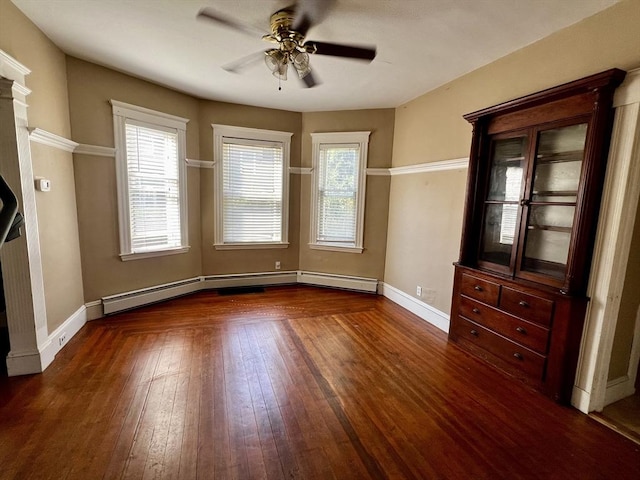 unfurnished dining area featuring ceiling fan, plenty of natural light, dark wood-type flooring, and a baseboard radiator