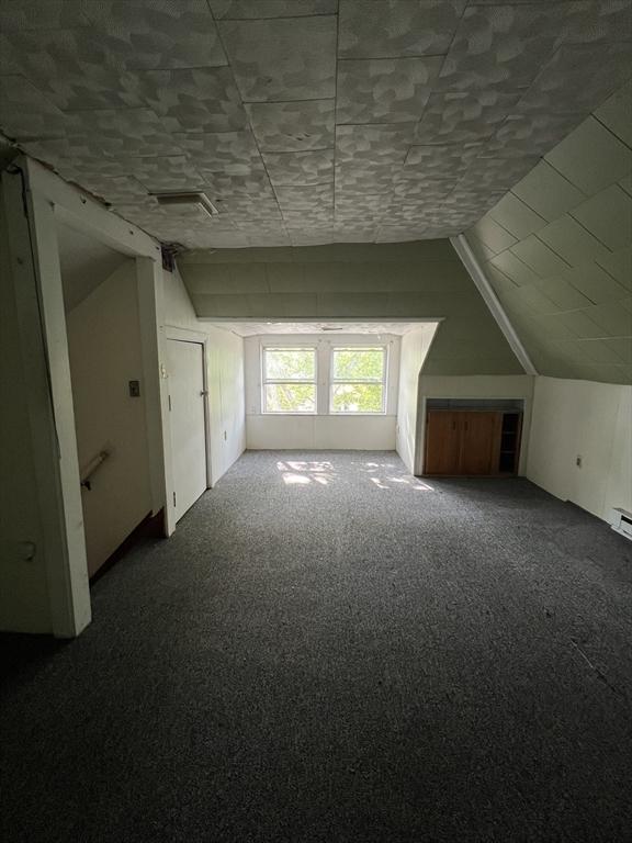 bonus room featuring carpet floors and vaulted ceiling