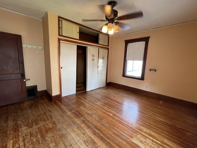 unfurnished bedroom with ceiling fan, a closet, and dark wood-type flooring