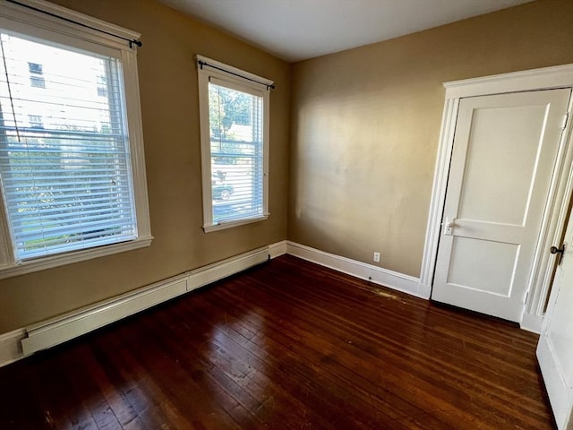 empty room featuring a baseboard radiator and dark hardwood / wood-style floors