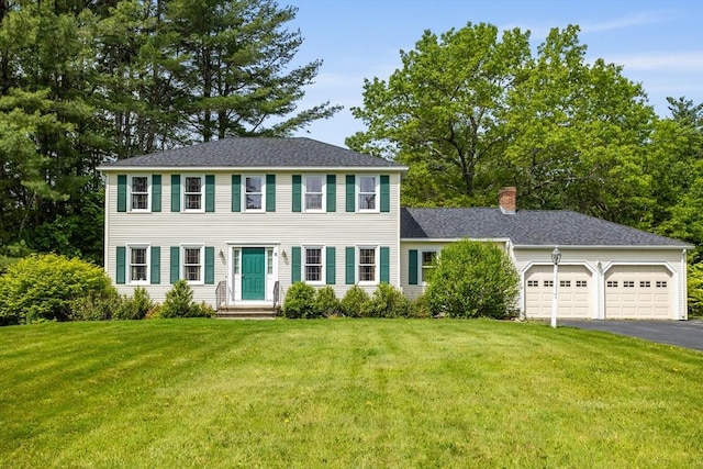 8 Macleod Ln, Acton, MA 01720 - colonial home featuring asphalt driveway, a garage, a chimney, a front lawn, and roof with shingles