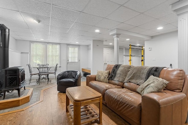 8 Macleod Ln, Acton, MA 01720 - living room featuring a wood stove, hardwood / wood-style floors, a drop ceiling, recessed lighting, and ornate columns