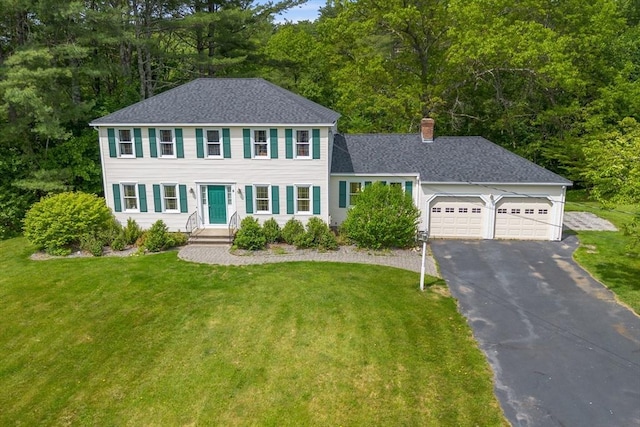 8 Macleod Ln, Acton, MA 01720 - colonial house featuring asphalt driveway, a chimney, a garage, and a front lawn