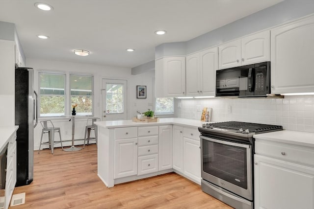 100 Summit, Brookline, MA 02446 - kitchen with stainless steel appliances, a peninsula, light wood-style floors, white cabinetry, and recessed lighting