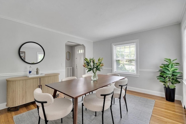 100 Summit, Brookline, MA 02446 - dining room featuring arched walkways, light wood-style floors, crown molding, and baseboards