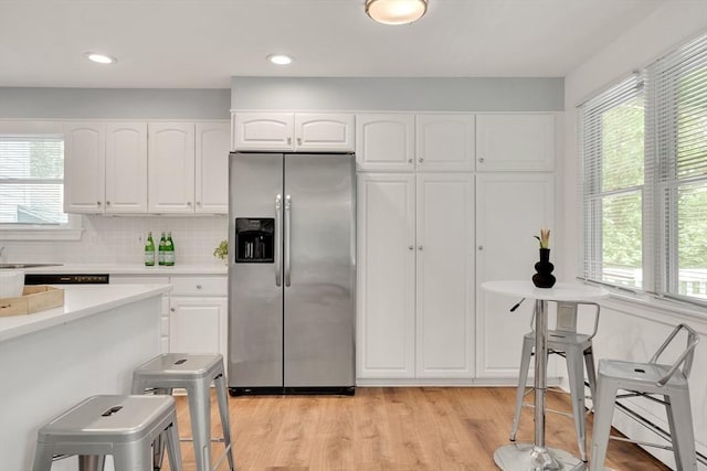 100 Summit, Brookline, MA 02446 - kitchen featuring stainless steel fridge with ice dispenser, healthy amount of natural light, and white cabinetry