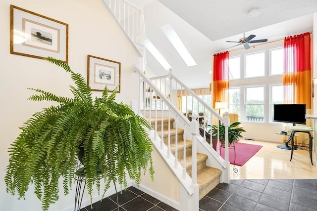 stairway featuring tile patterned flooring and ceiling fan